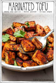Spoon in bowl of marinated tofu.