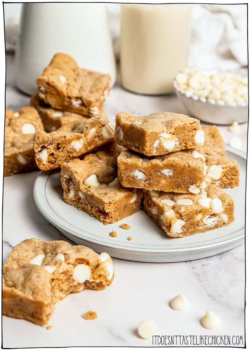 These soft, chewy vegan blondies have rich caramel flavor for bakery-style vibes. An easy one bowl recipe made egg-free and dairy-free! Stack of vegan blondies on plate and on countertop.