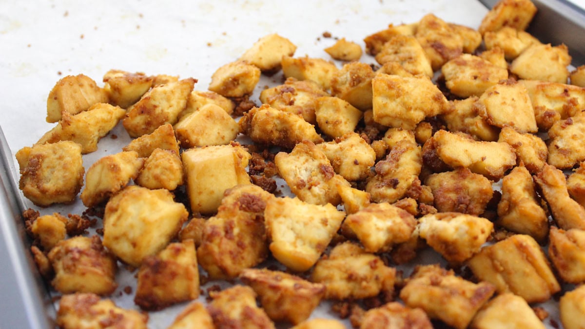 Golden brown crispy tofu on a baking sheet.