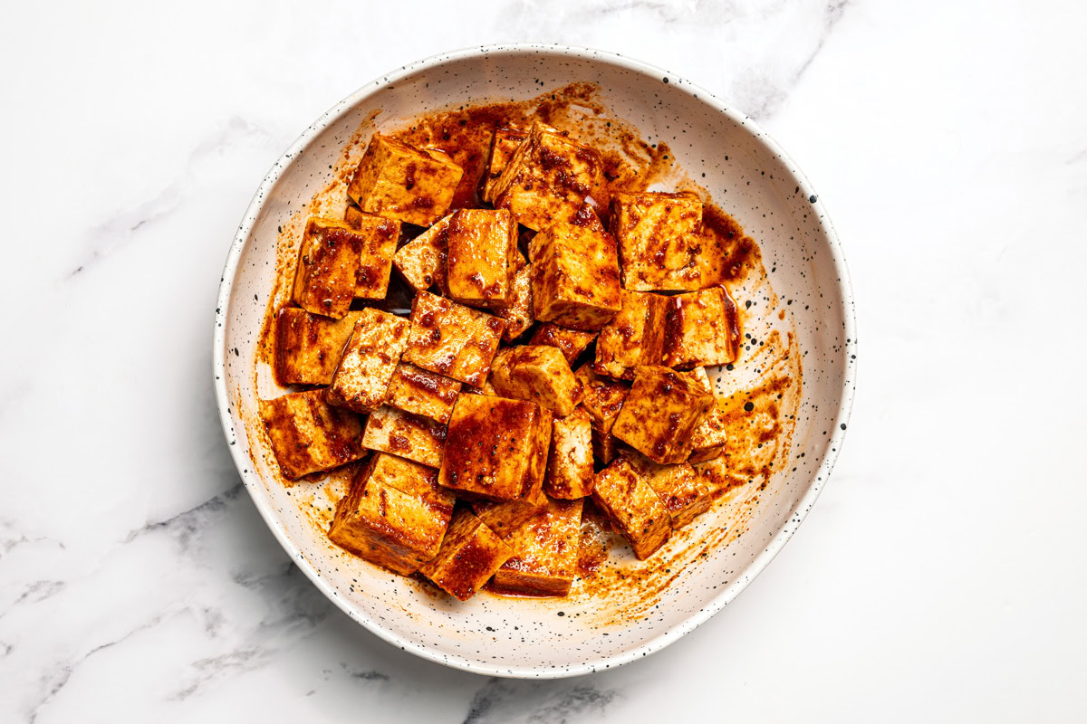 Cubed tofu in a bowl covered in marinade.