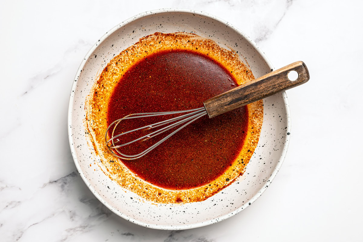 Tofu marinade in bowl with whisk.