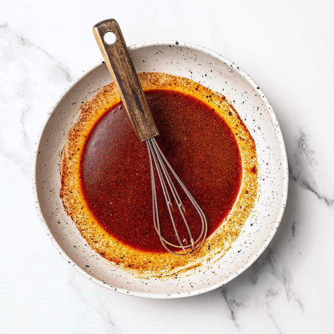 Tofu marinade in bowl with whisk.