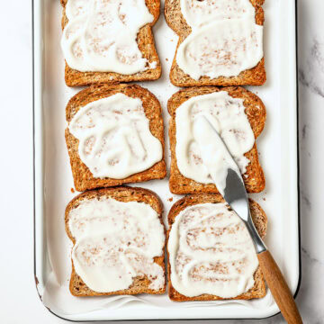 Spreading vegan mayo onto toasted slices of bread.