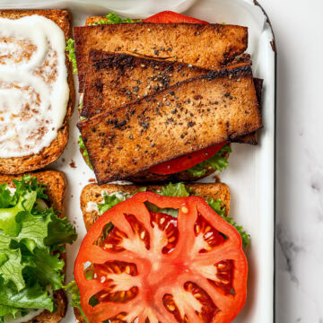 Tofu bacon, tomato slices, and lettuce layered onto toasted bread.