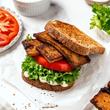 Assembled vegan BLT on parchment paper.