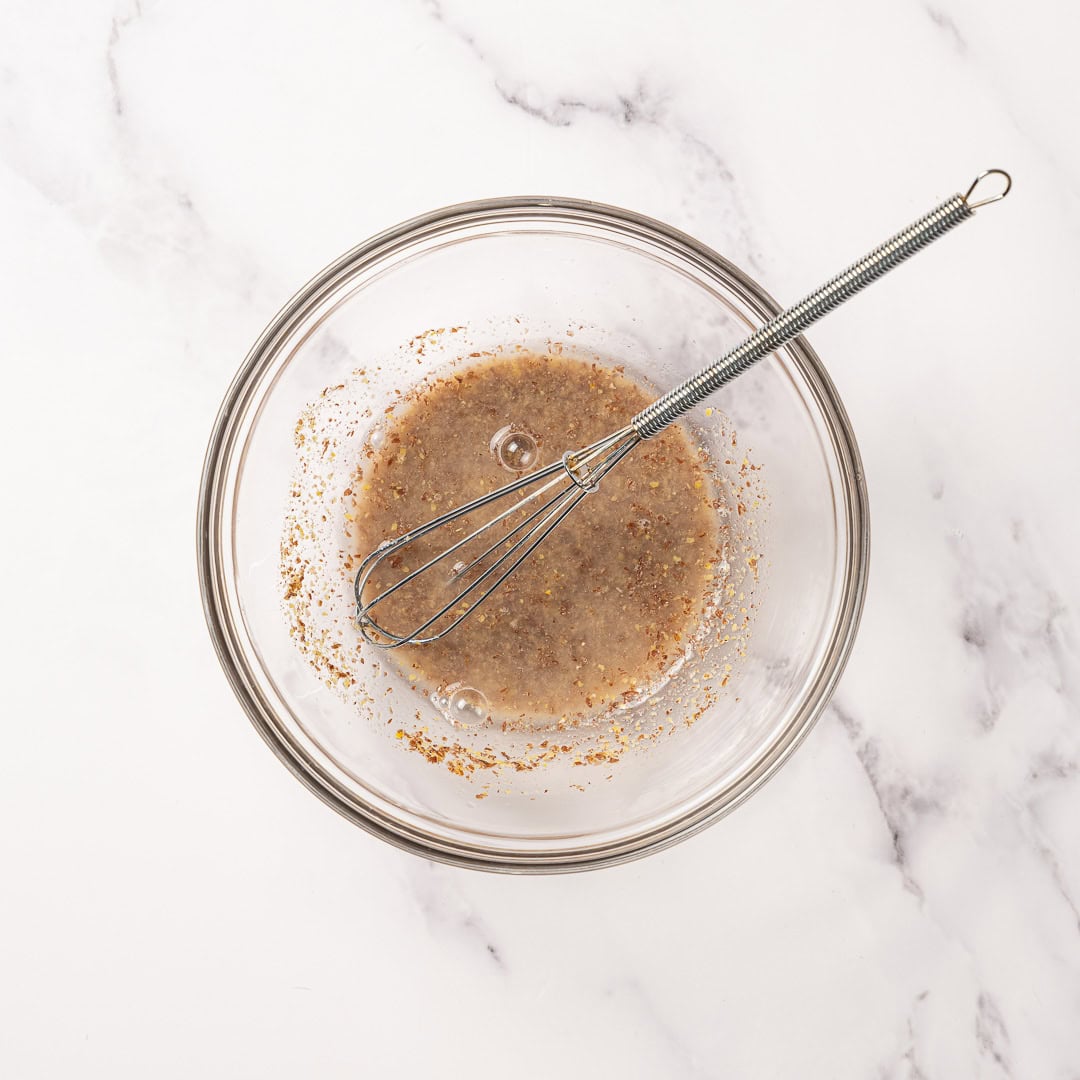 These soft, chewy vegan blondies have rich caramel flavor for bakery-style vibes. An easy one bowl recipe made egg-free and dairy-free! Flax egg in bowl with whisk.