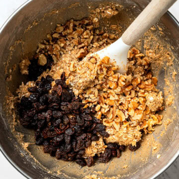 Stirring nuts and raisins into oatmeal cookie dough.