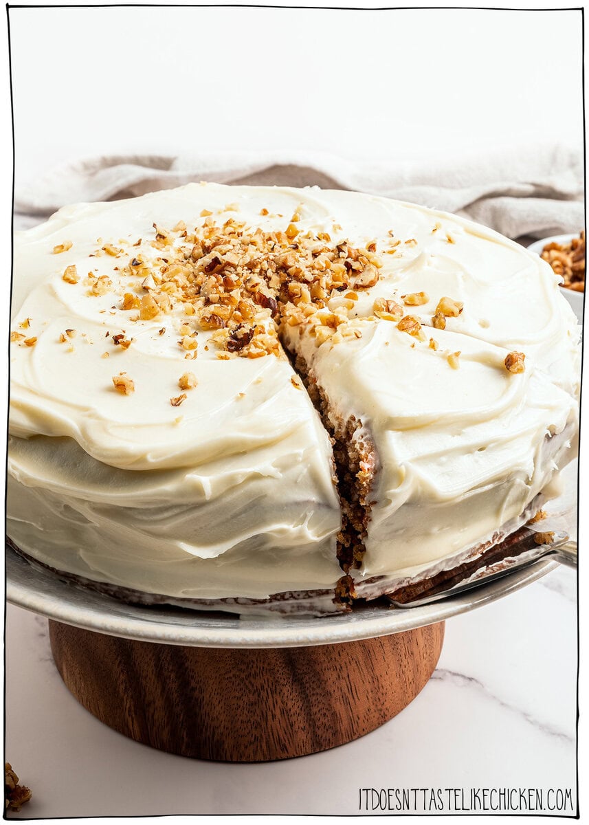 Slice cut from vegan carrot cake on a cake stand.
