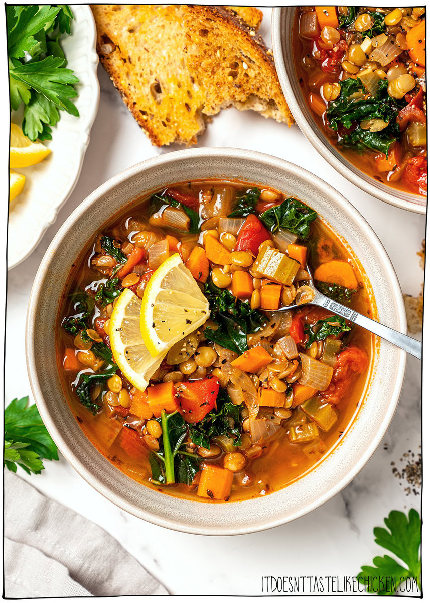 This easy lentil soup is a cozy one-pot recipe made with simple pantry ingredients! A hearty, healthy vegan meal perfect for meal prep. Bowl of easy lentil soup with spoon and lemon wedges.