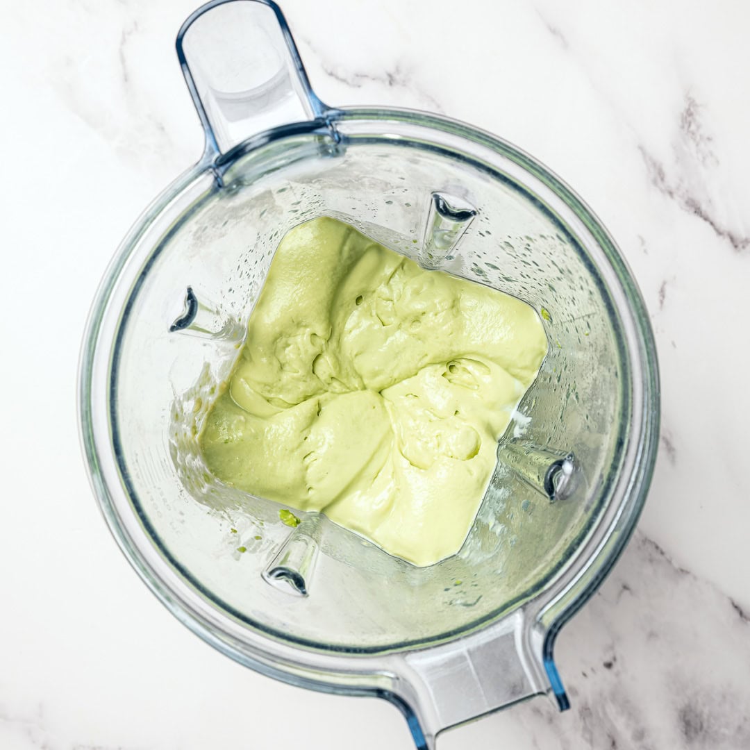 Creamy dairy-free avocado crema made in 5 minutes! Perfect for tacos, bowls, nachos, and more. Fresh, tangy, and super easy to make. Avocado crema in jar of blender.