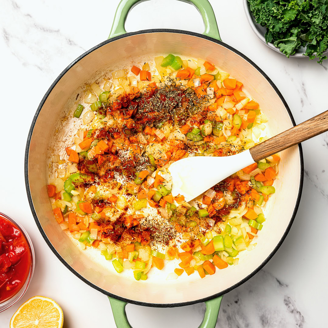 This easy lentil soup is a cozy one-pot recipe made with simple pantry ingredients! A hearty, healthy vegan meal perfect for meal prep. Seasonings added to mirepoix in Dutch oven.