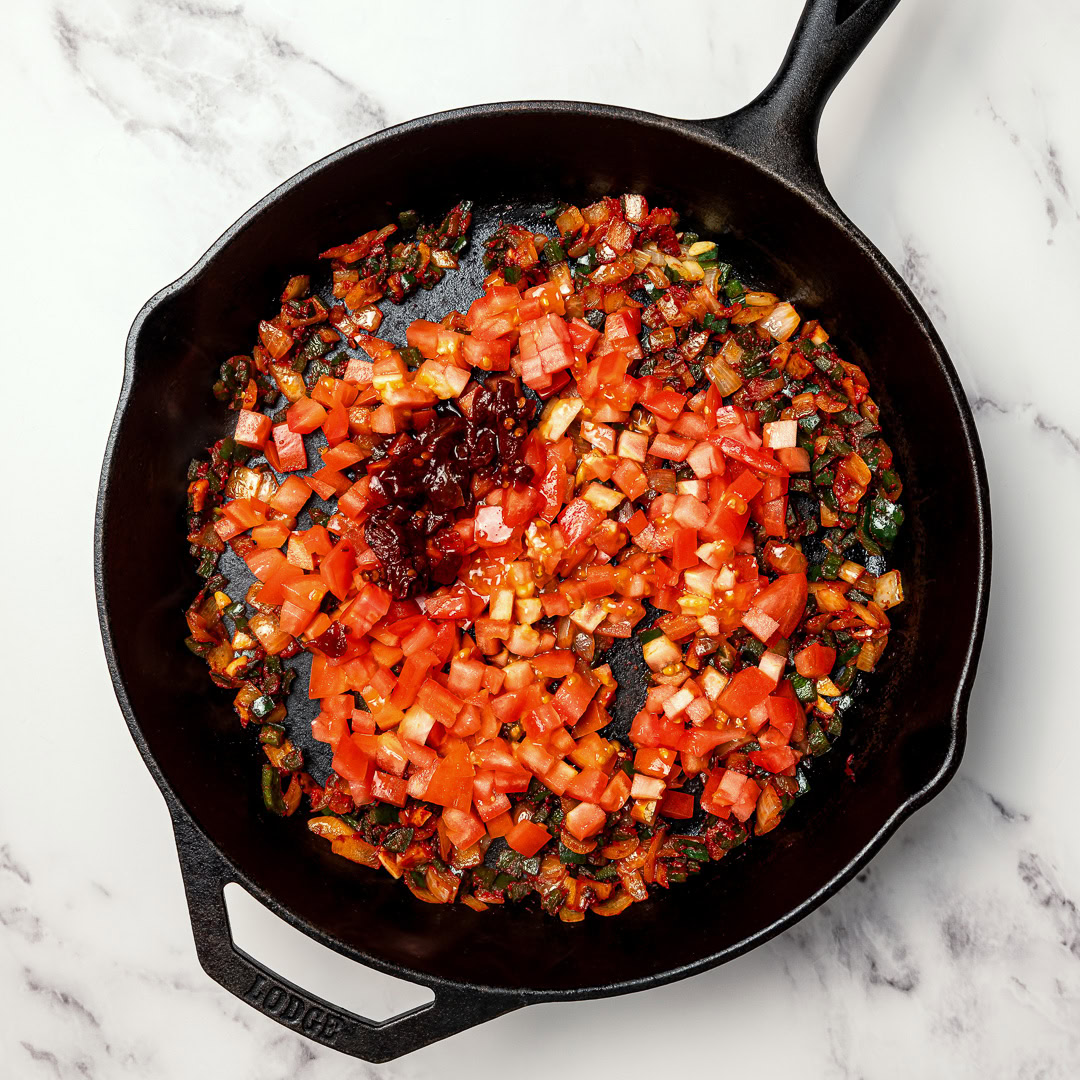 These smoky, saucy vegan sofritas are made in one pan with tofu, chipotle, and spices. Perfect for tacos, bowls, burritos, and meal prep! Tomatoes added to skillet for sofritas sauce.