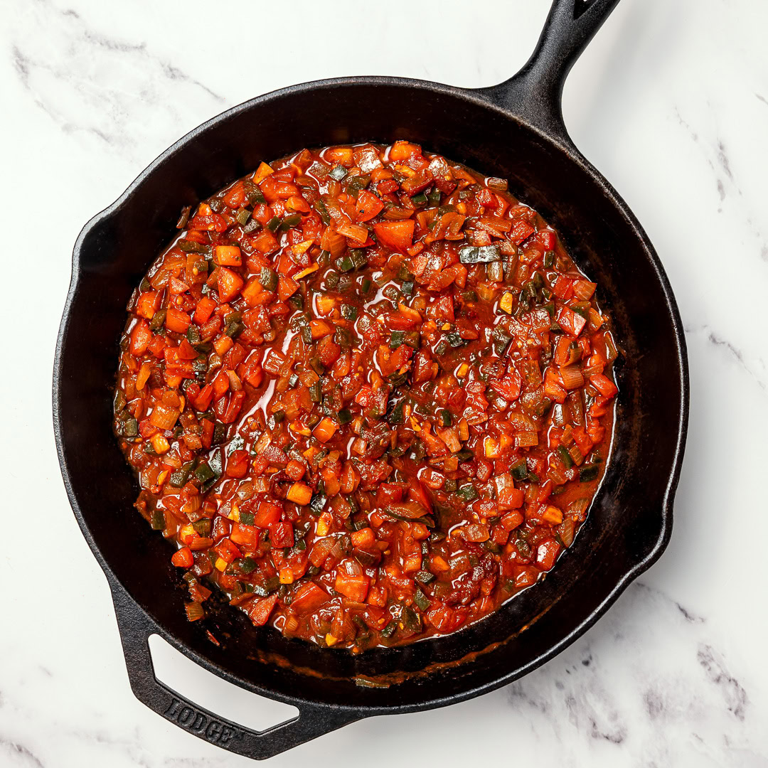 These smoky, saucy vegan sofritas are made in one pan with tofu, chipotle, and spices. Perfect for tacos, bowls, burritos, and meal prep! Tomatoes and peppers simmering in skillet.