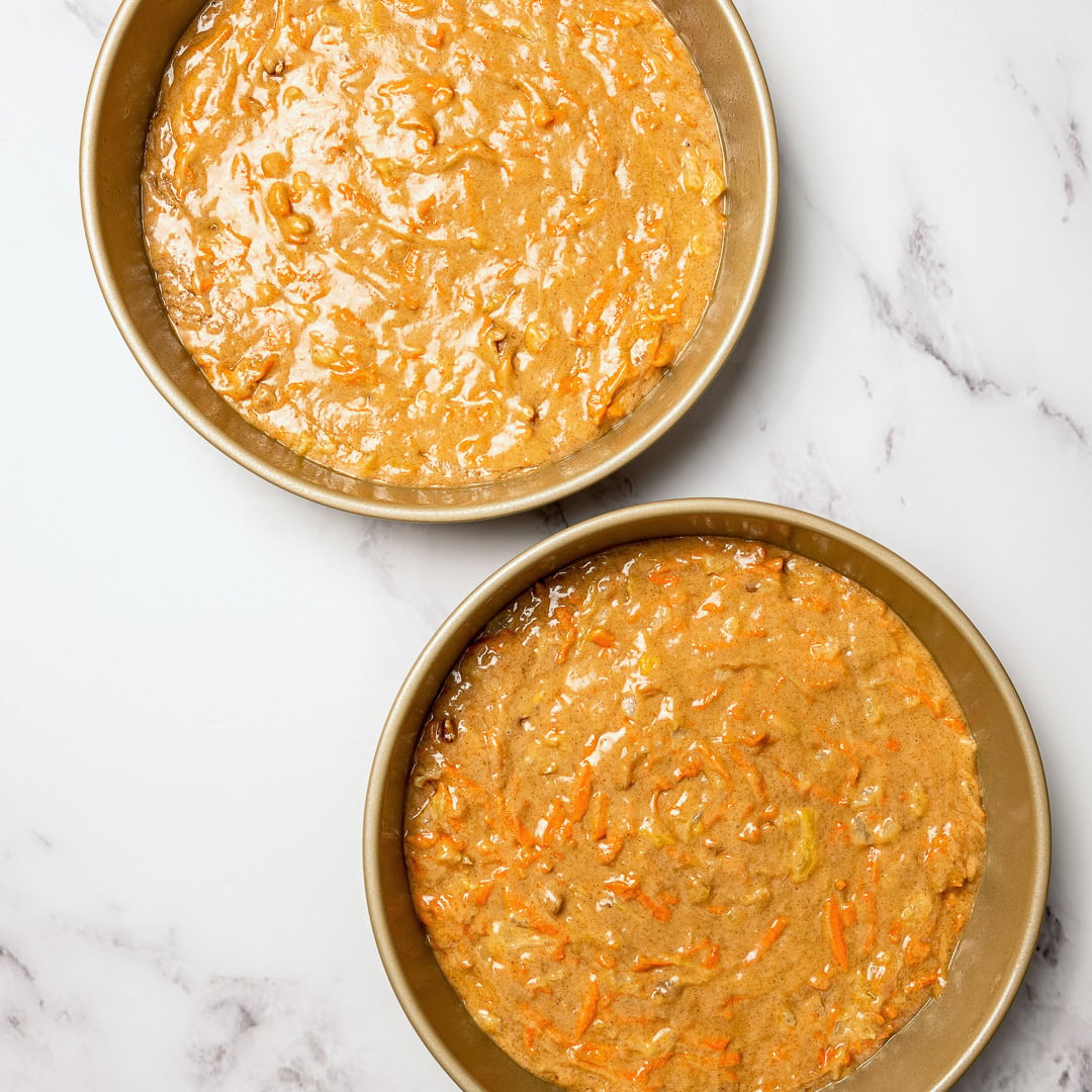 Vegan carrot cake batter in two round pans.