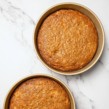 Two vegan carrot cake layers in round pans.