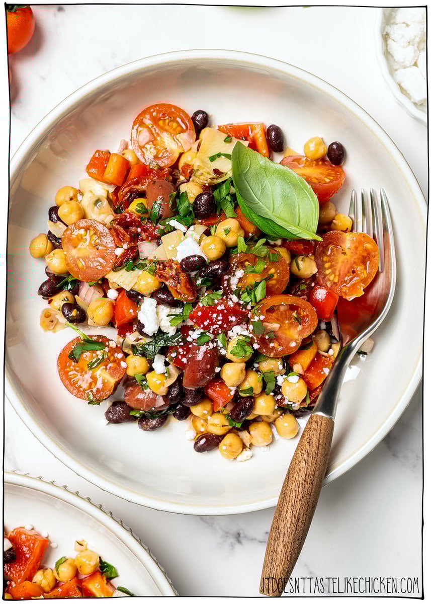 Dense bean salad packs hearty beans, crunchy veggies, and bold dressing into a satisfying make-ahead dish that stays tasty all week long! Plate of dense bean salad with fork.