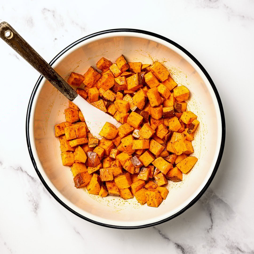 Air fryer sweet potatoes turn out crispy on the edges and tender inside, making a quick, flavorful side dish you'll make on frequent repeat! Bowl of sweet potatoes tossed with oil and seasonings.