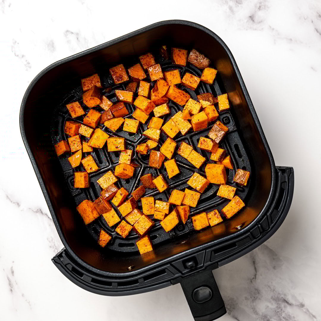 Air fryer sweet potatoes turn out crispy on the edges and tender inside, making a quick, flavorful side dish you'll make on frequent repeat! Seasoned raw sweet potatoes in air fryer basket.