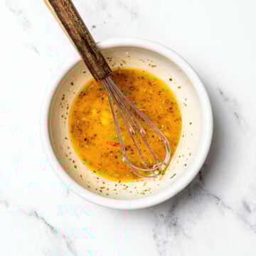 Whisk in bowl with dense bean salad dressing.