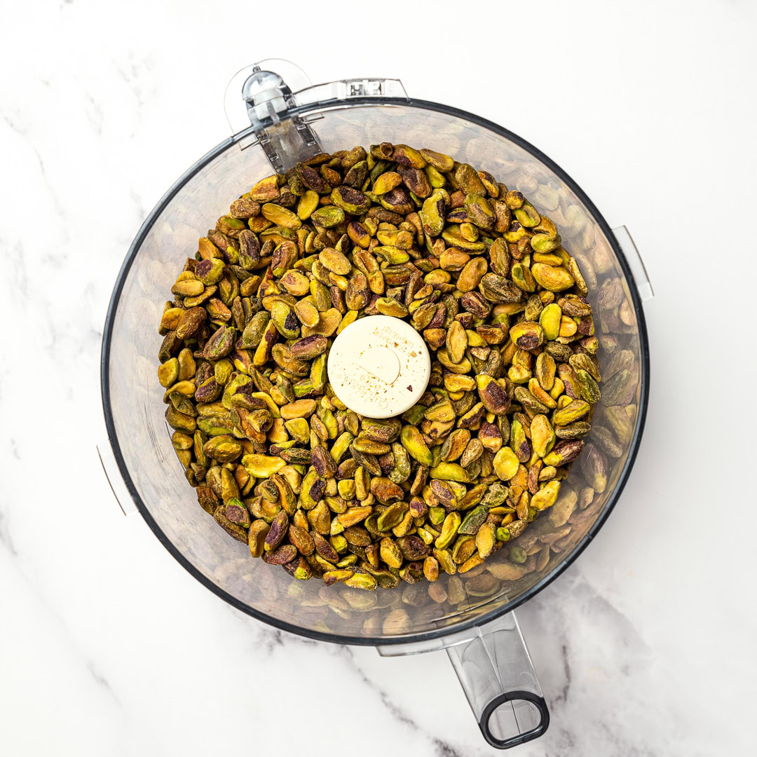 Roasted pistachios blend into a smooth homemade pistachio butter that tastes amazing on toast or straight from the spoon. Just 1 ingredient! Roasted pistachios in food processor.