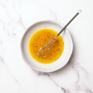 Vinaigrette in shallow bowl with whisk.