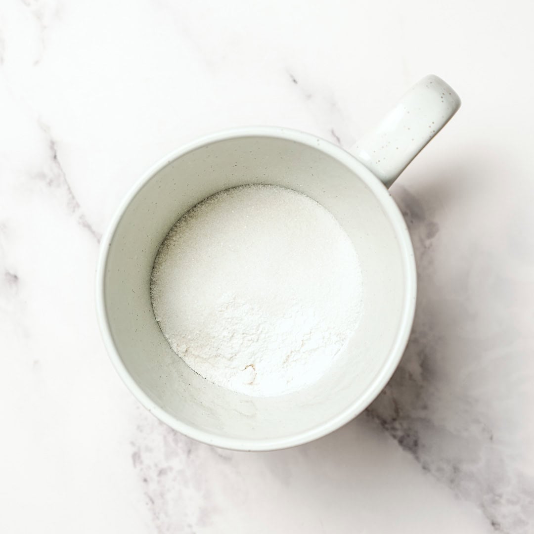 Soft, fluffy, and ready in just 5 minutes, this vegan vanilla mug cake is the perfect single-serve dessert when a sweet craving hits! Dry ingredients for cake in mug.