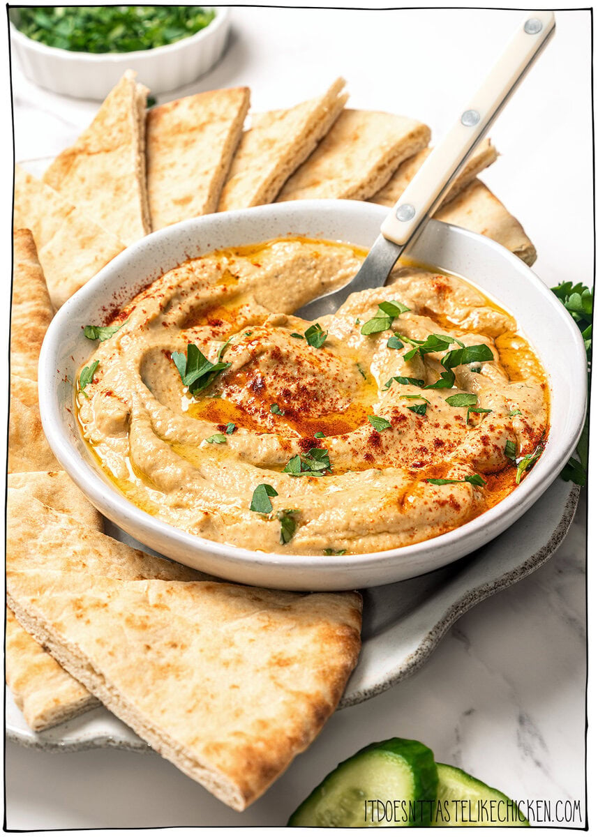 This easy baba ganoush is unbelievably creamy, smoky, and full of rich flavor, and you only need a handful of simple ingredients to make it! Bowl of baba ganoush on plate with pita bread.