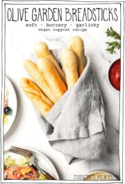 Breadsticks wrapped in linen towel with text overlay that reads Olive Garden breadsticks.