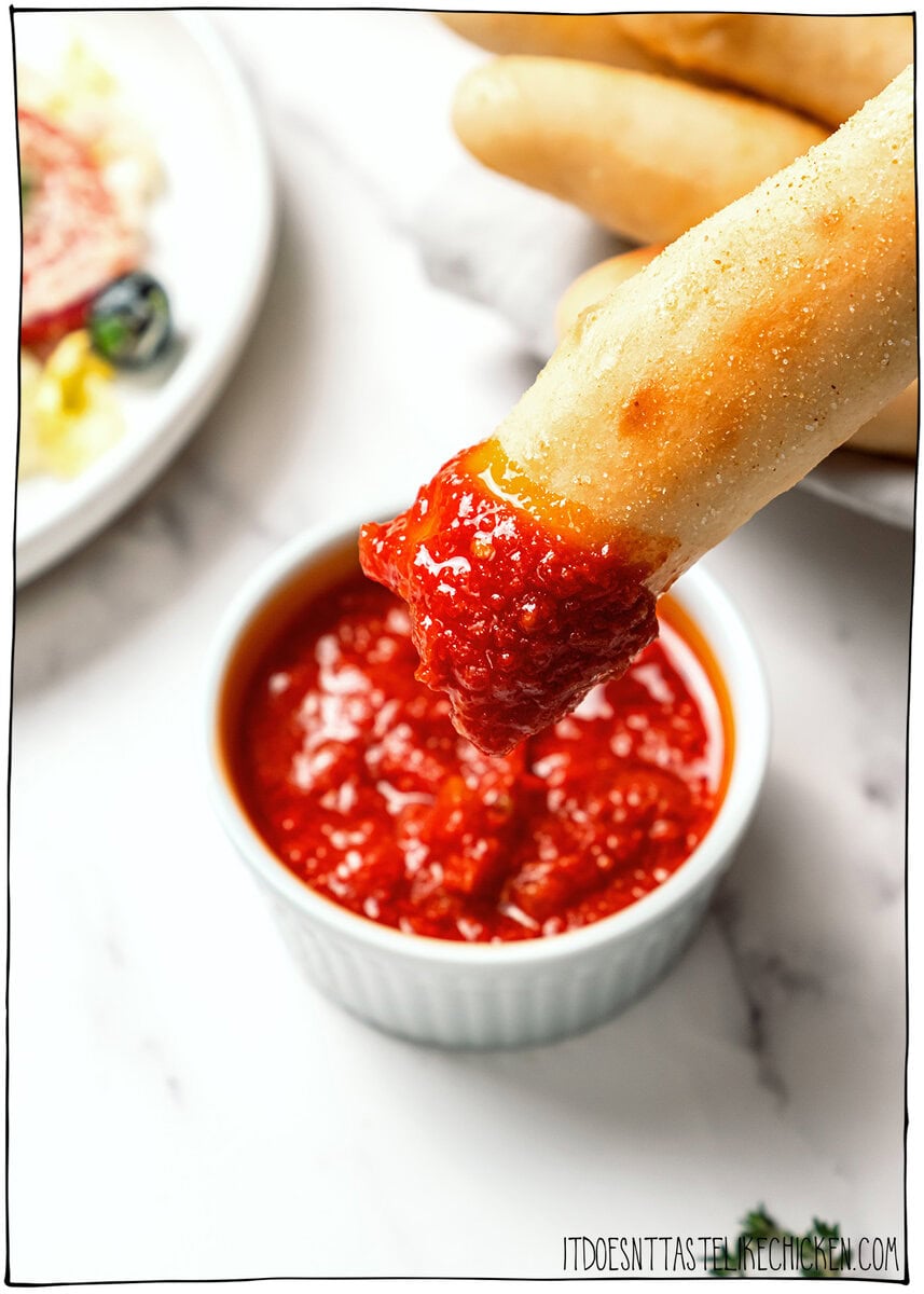 These vegan Olive Garden breadsticks are soft, fluffy, and brushed with buttery garlic salt, just like the restaurant. So irresistible! Vegan breadsticks dipped into marinara.