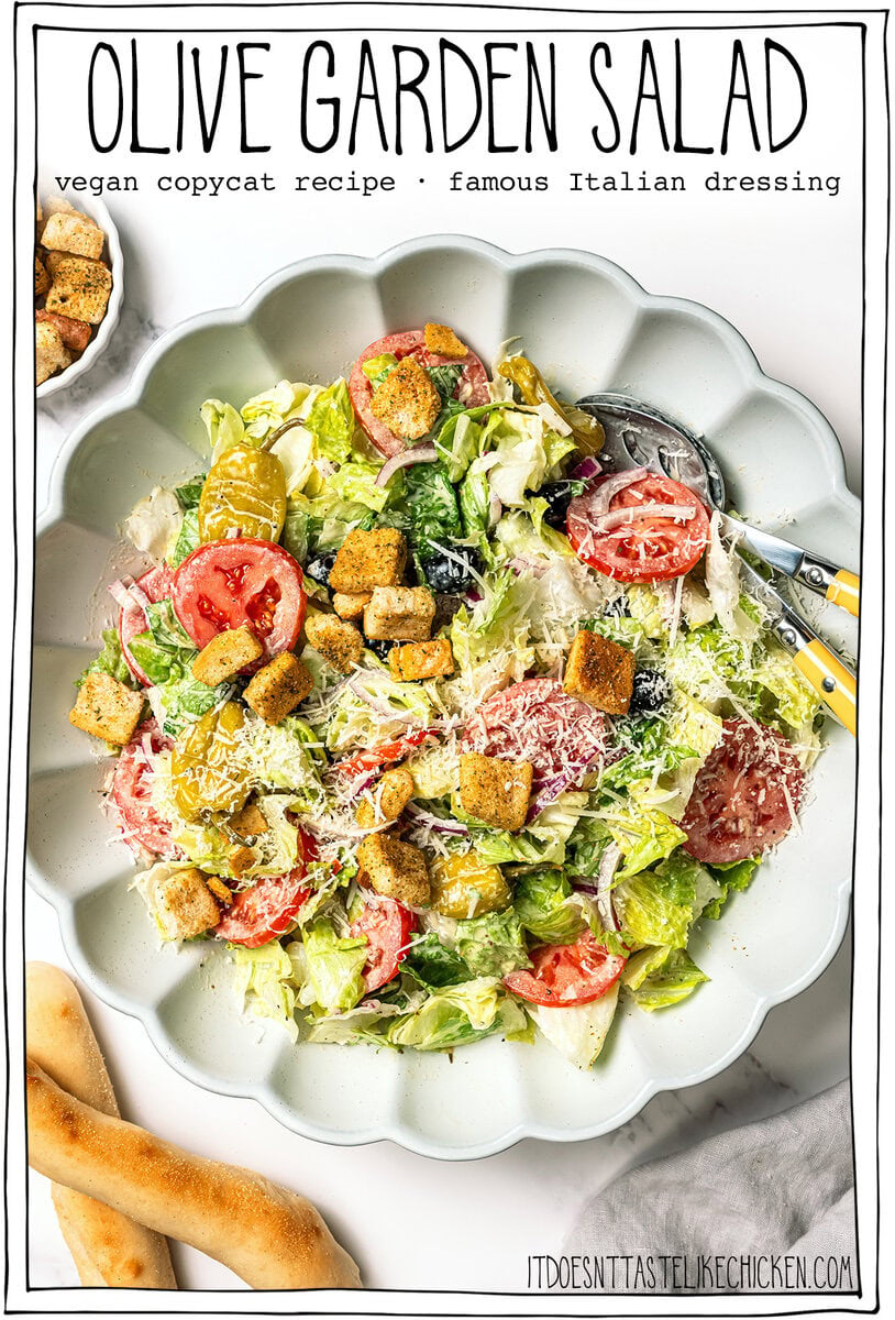 This vegan Olive Garden salad tastes just like the classic, with crisp lettuce, juicy tomatoes, olives and creamy, tangy Italian dressing! Bowl of salad with text overlay that reads Olive Garden salad.