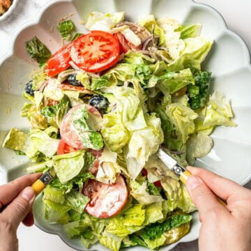 Tossing Olive Garden salad in bowl.