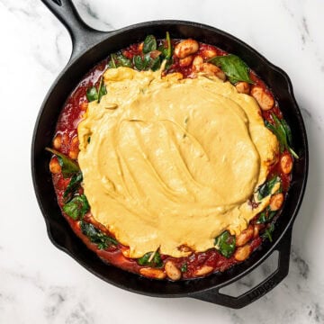 Vegan cheese sauce added to skillet of pizza beans.