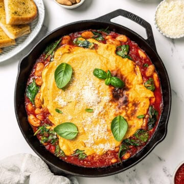 Skillet of vegan pizza beans with fresh basil.