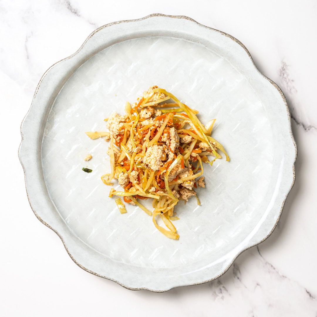 These vegan rice paper dumplings are crispy on the outside, chewy around the edges, with a savory cabbage and tofu filling. Viral on TikTok! Tofu and cabbage filling on sheet of rice paper.