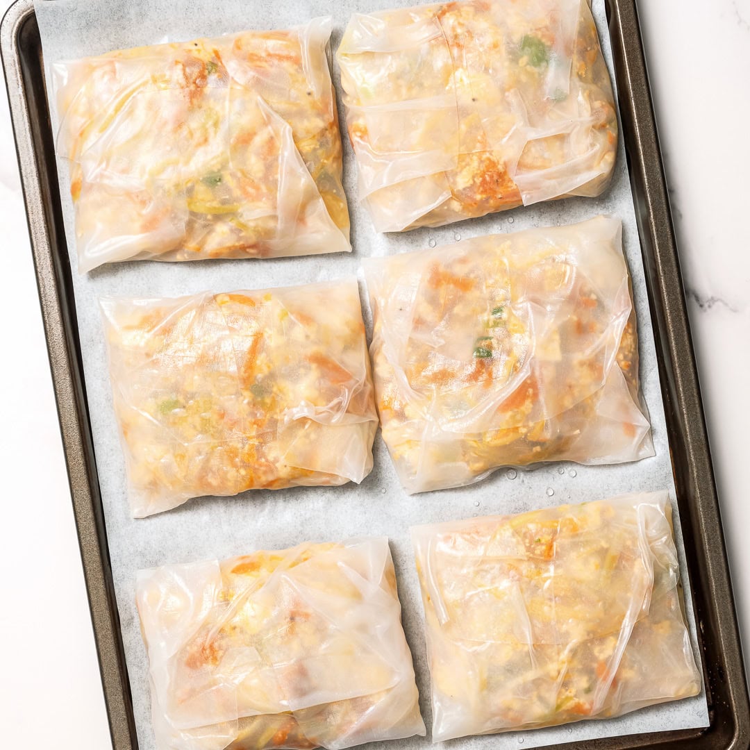 These vegan rice paper dumplings are crispy on the outside, chewy around the edges, with a savory cabbage and tofu filling. Viral on TikTok! Tofu rice paper dumplings on parchment lined sheet pan.