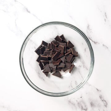 Chopped chocolate pieces in glass bowl.
