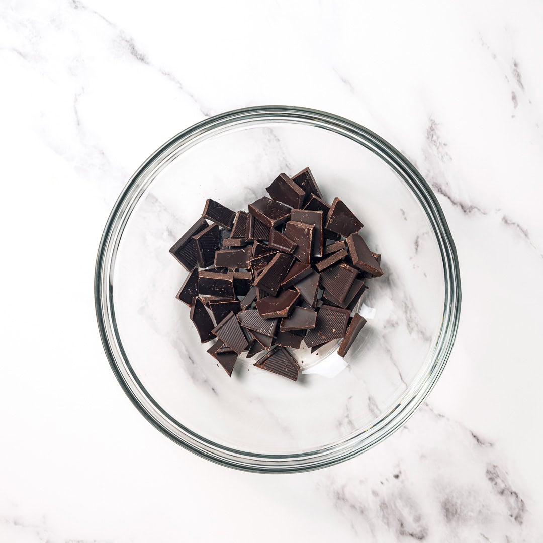 This Silken Tofu Chocolate Mousse is rich, silky, deeply chocolatey, and you'd never guess it's made with tofu. Whips up in minutes! Chopped chocolate pieces in glass bowl.