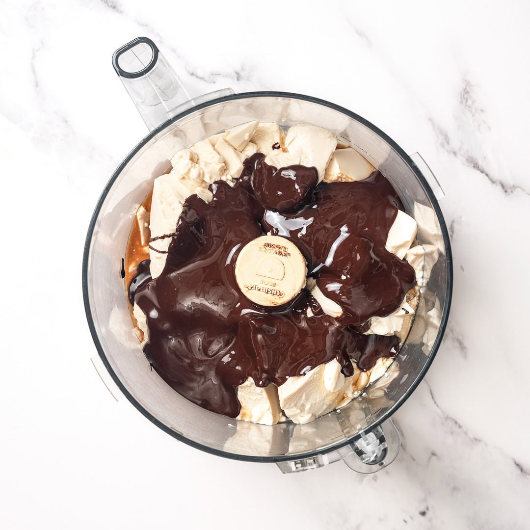 This Silken Tofu Chocolate Mousse is rich, silky, deeply chocolatey, and you'd never guess it's made with tofu. Whips up in minutes! Melted chocolate in food processor with silken tofu.