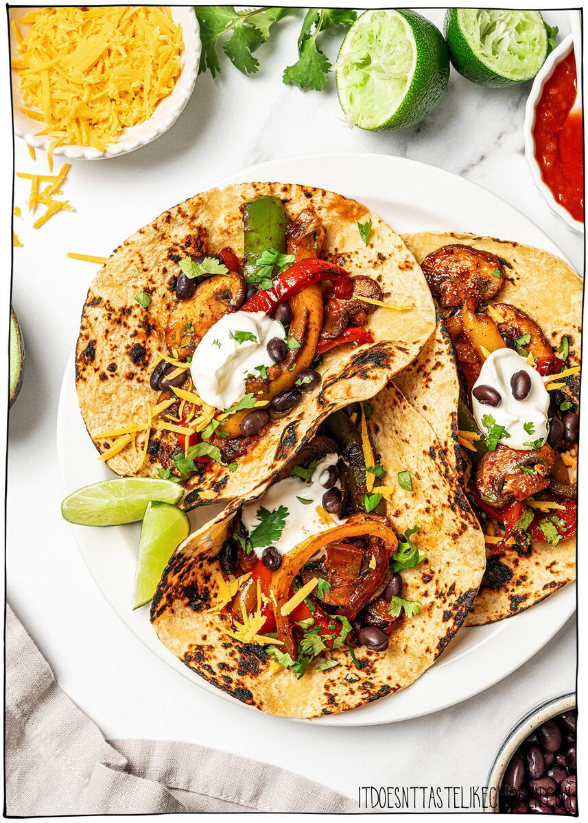 Three tortillas topped with fajita veggies and vegan sour cream.