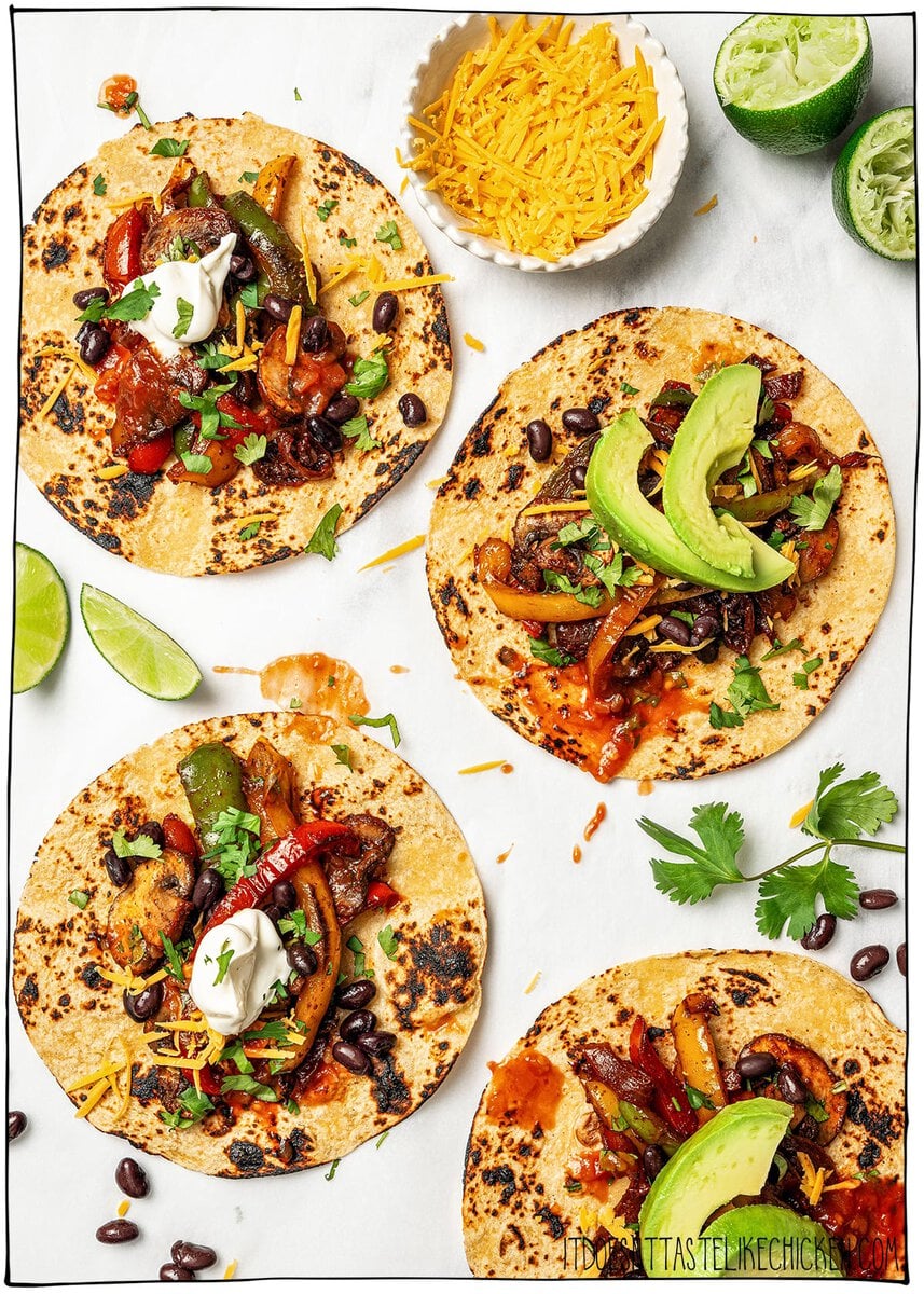 Four charred tortillas topped with fajita veggies.