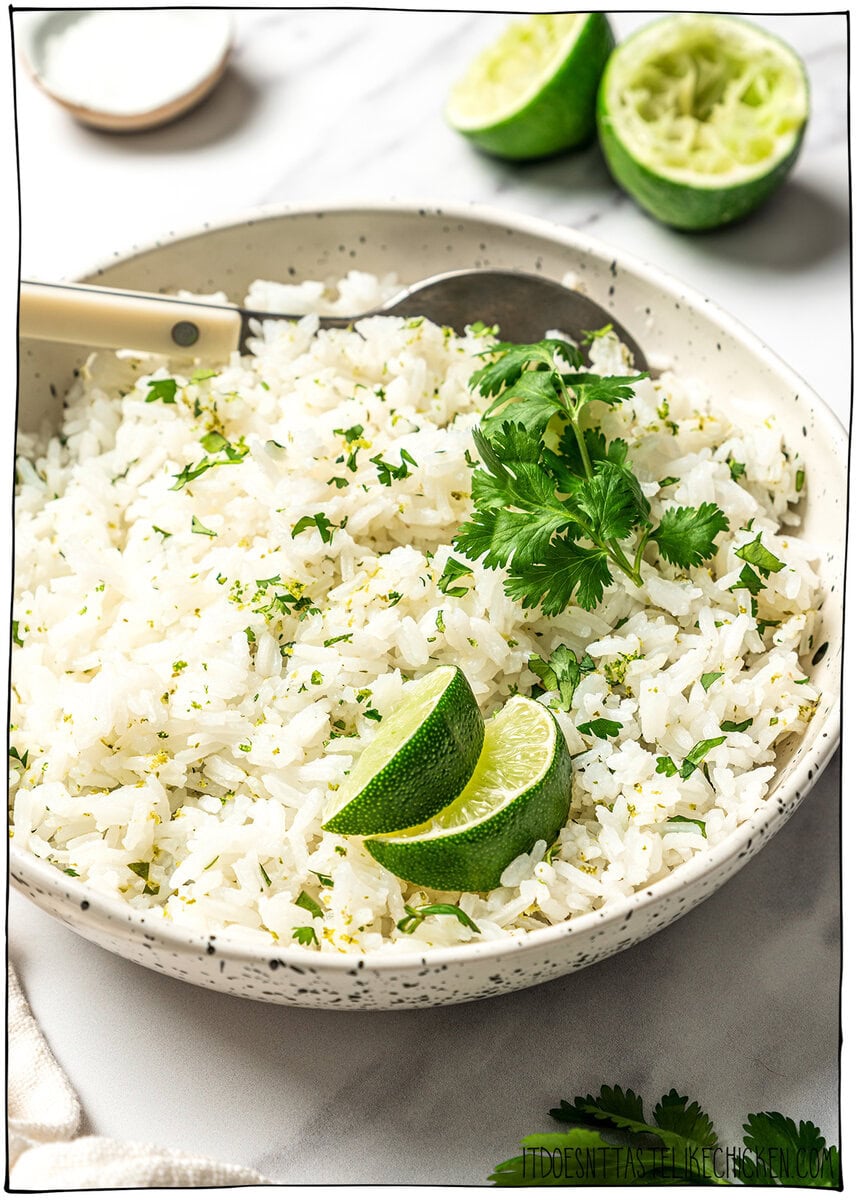 This easy Chipotle rice recipe is fluffy, lightly seasoned, and finished with fresh lime juice and cilantro for that signature fresh flavor! Bowl of chipotle cilantro lime rice with spoon.