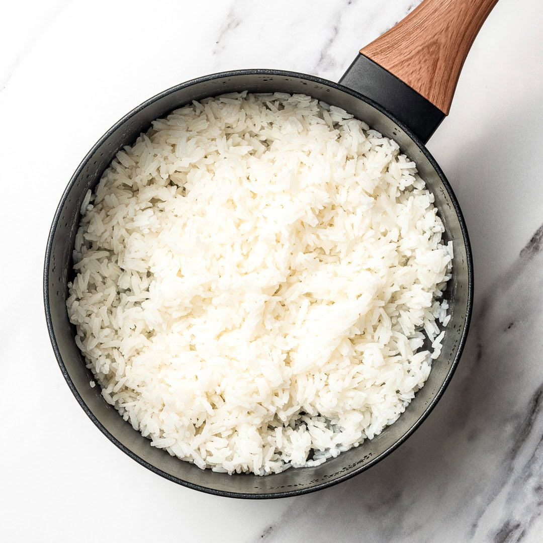 This easy Chipotle rice recipe is fluffy, lightly seasoned, and finished with fresh lime juice and cilantro for that signature fresh flavor! Pot of cooked white rice.