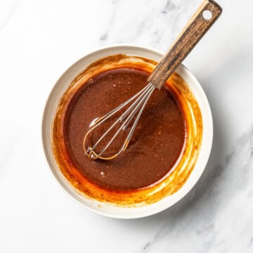 Pad thai sauce in bowl with whisk.
