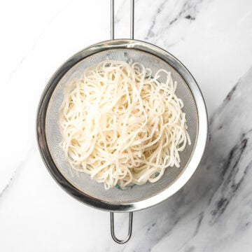 Rice noodles in colander.