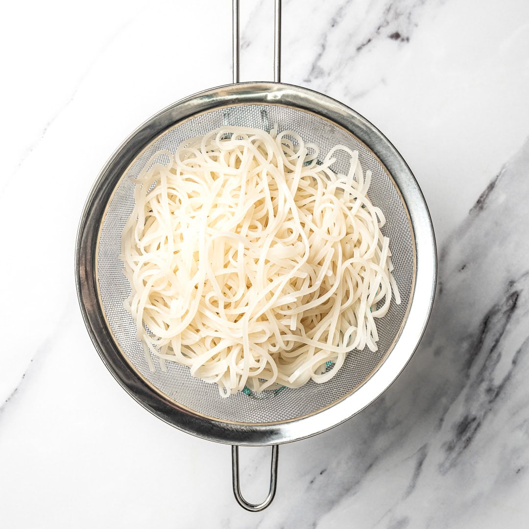 Rice noodles in colander.