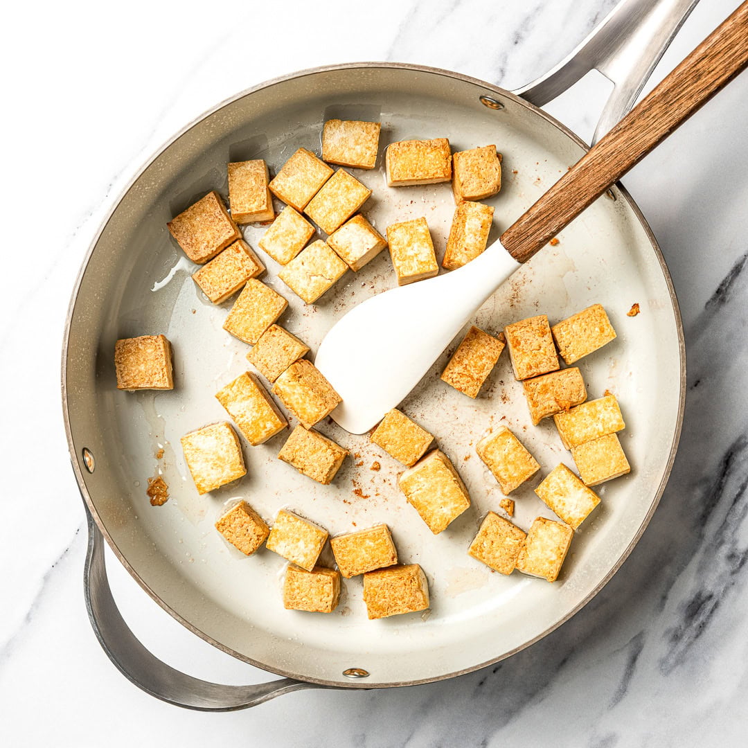 Tofu cooking in skillet.