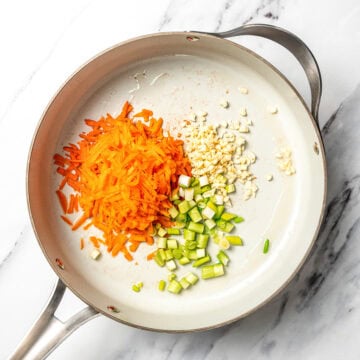 Carrots, green onions, and garlic in skillet with oil.