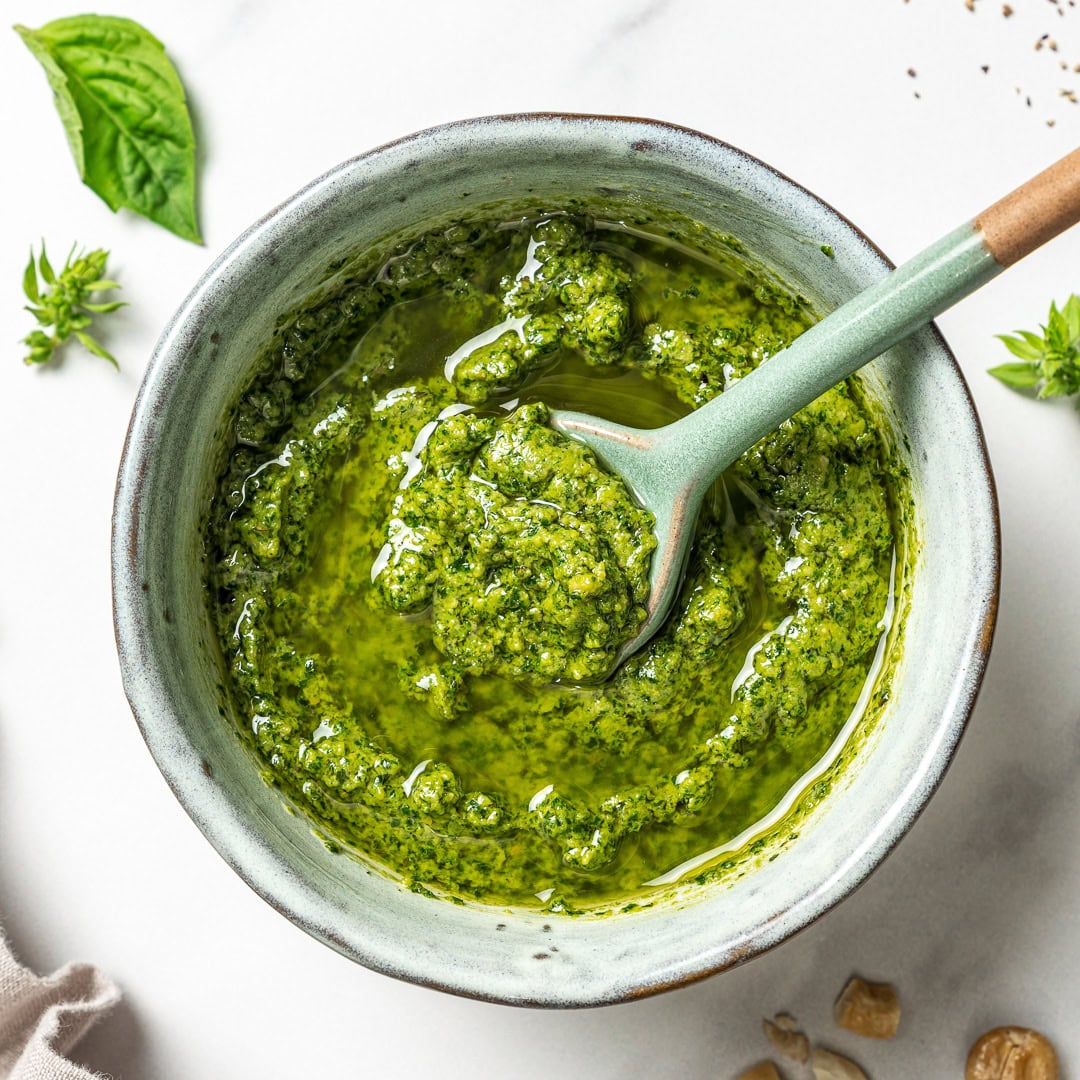 Spoon in bowl of vegan pesto.