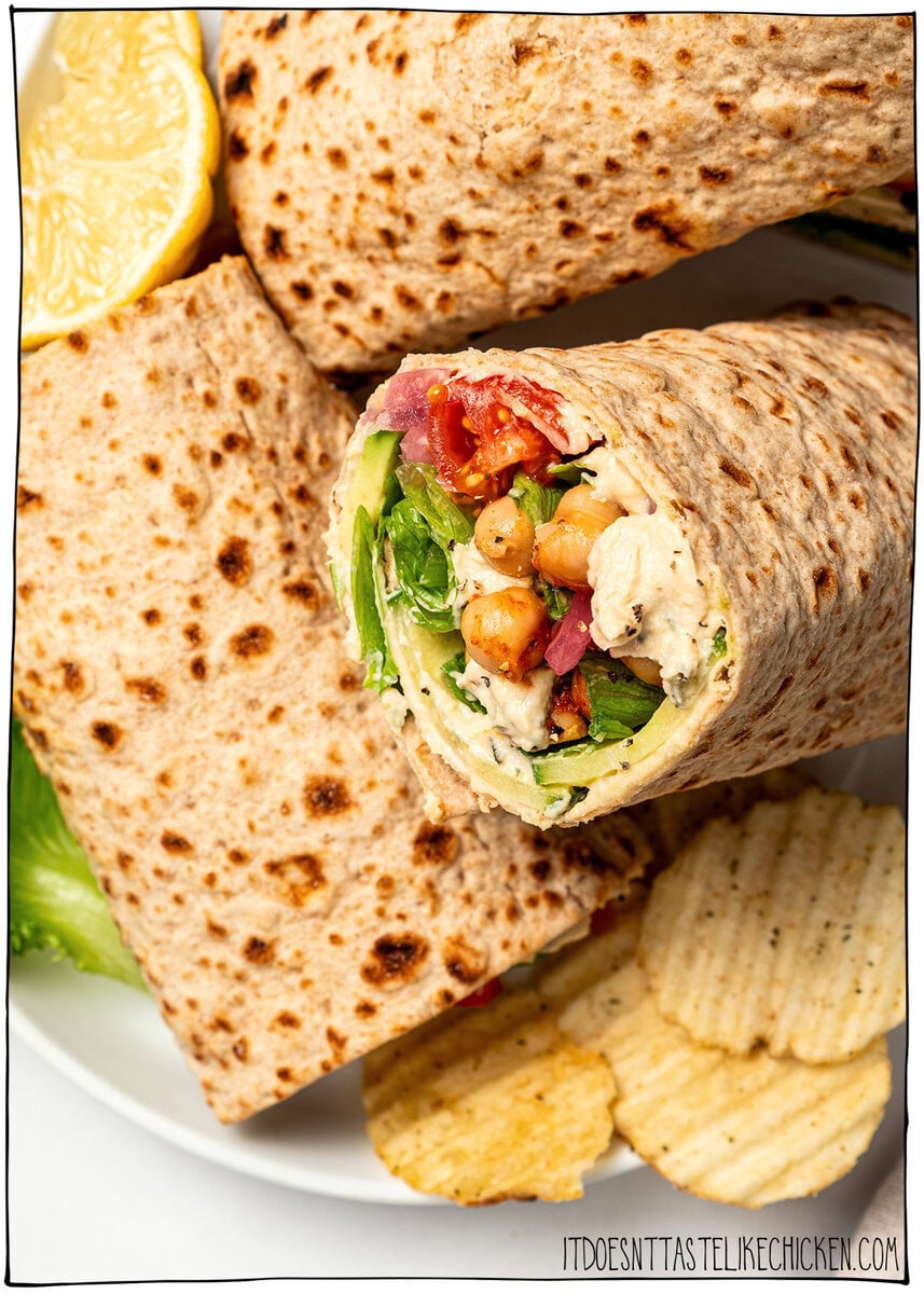 Made with simple ingredients in just 10 minutes, this crunchy hummus veggie wrap is perfect for lunch, meal prep, or an easy no-cook dinner! Veggie wraps with hummus on plate with potato chips.