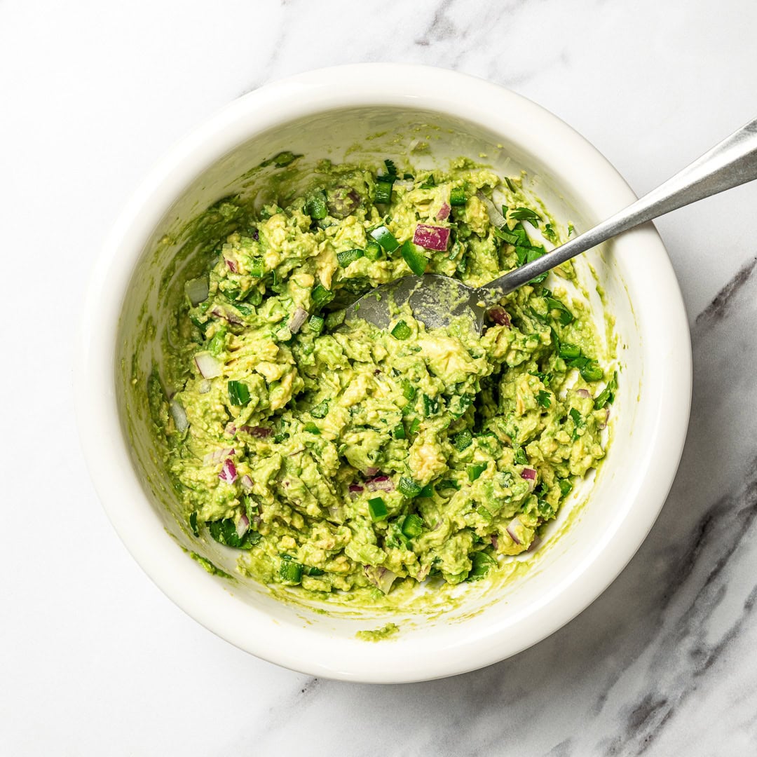 This easy Chipotle guacamole recipe is creamy, bright, and packed with fresh flavor, just like the restaurant version. Only 5 ingredients! Spoon in bowl of Chipotle-style guacamole.